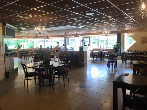 a dining room with tables and chairs in a restaurant at De Waterlelie gezellig en sfeervol aan het water in Gramsbergen