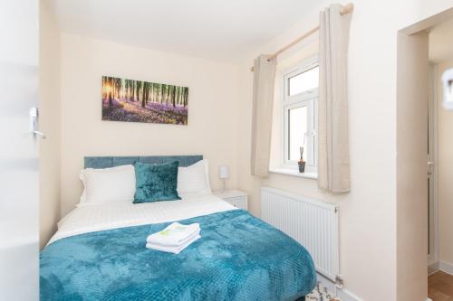 een slaapkamer met een bed met een blauwe deken bij Modern Studio Apartments in Castle St in Southampton