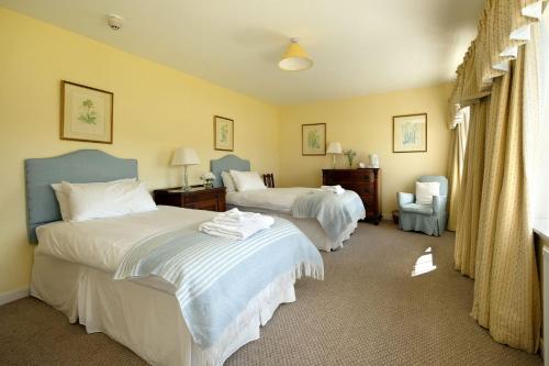 a hotel room with two beds and a chair at Bruntlands Steading in Fochabers