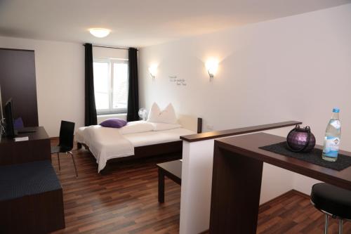 a living room with a bed and a table at Hotel am Marktplatz in Gangkofen