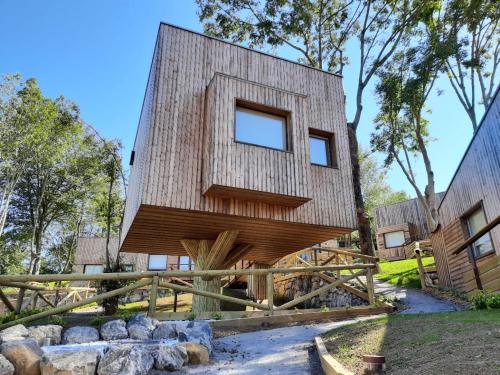 a tree house with a wooden facade at CieloAstur Complejo Turístico in Linares