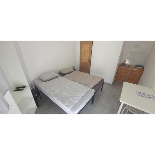 een kleine kamer met een bed en een tafel bij Budget Apartman LeLo Centar 3 in Osijek