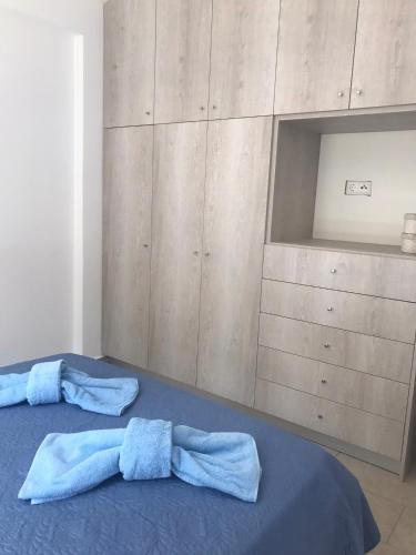 a bedroom with a blue bed with two pillows at Aegean Mirror, Andros in Apróvaton