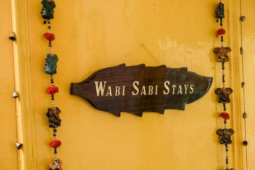 a sign that reads waldell saab stays hanging on a wall at SUN 2BHK by Wabi Sabi Stays Steep Uphill walk 5 Mins in Mussoorie