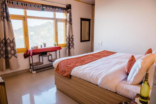 a bedroom with a bed and a window and a sink at SUN 2BHK by Wabi Sabi Stays Steep Uphill walk 5 Mins in Mussoorie