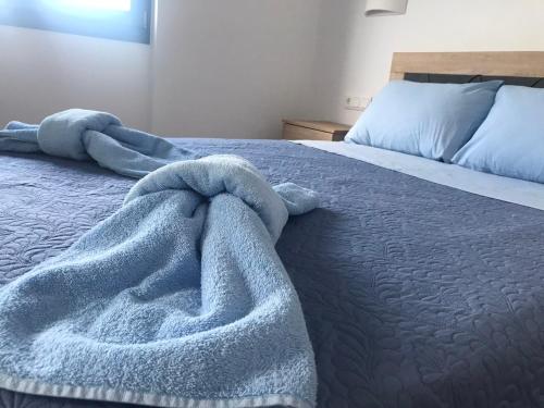 a blue blanket laying on top of a bed at Aegean Mirror, Andros in Apróvaton
