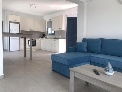 a living room with a blue couch and a table at Aegean Mirror, Andros in Apróvaton