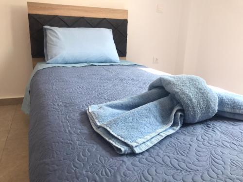 a bed with a blue blanket on it at Aegean Mirror, Andros in Apróvaton