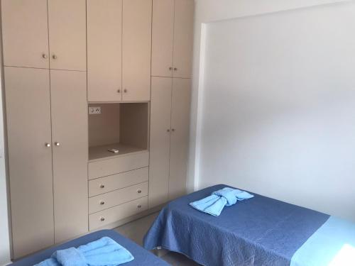 a bedroom with a bed and cabinets and towels at Aegean Mirror, Andros in Apróvaton