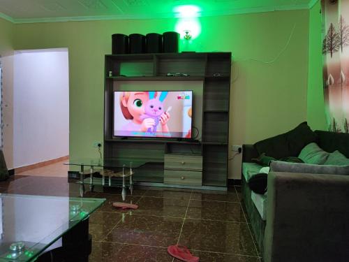 una sala de estar con TV con un cerdo en la pantalla en Camp-Flo 3br Guest House-Eldoret en Eldoret