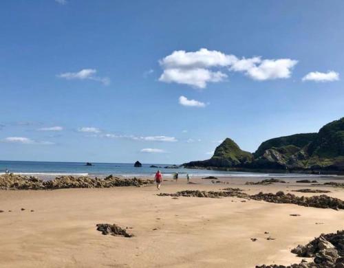 a person walking on a beach near the ocean at Lower Bruntlands in Fochabers