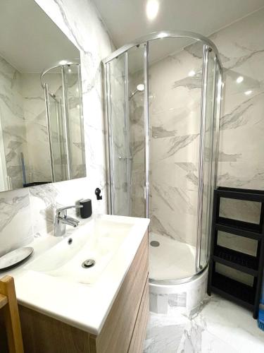 une salle de bain blanche avec une douche et un lavabo dans l'établissement FANNY - Hyper centre - Wifi - 4 personnes, à Cassis