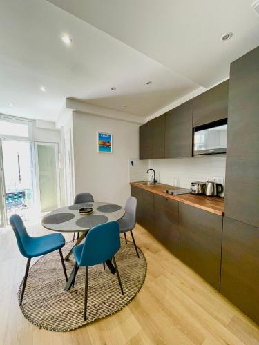 une cuisine avec une table et des chaises dans une pièce dans l'établissement FANNY - Hyper centre - Wifi - 4 personnes, à Cassis