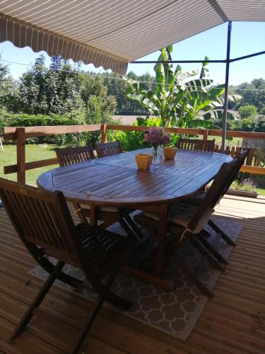 une table et des chaises en bois sur une terrasse dans l'établissement Holli cottage - Charming 2 bedrooms with terrace., à Saint-Avit-Rivière