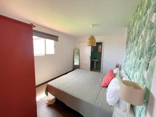 Un dormitorio con una cama grande y una ventana en Casa con piscina y jardín con vistas al mar, en Puerto de la Madera