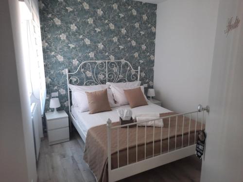 una camera da letto con un letto con carta da parati floreale di GUEST HOUSE TRA CIELO E MARE a Nettuno