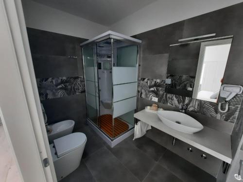 ein Bad mit einer Dusche, einem Waschbecken und einem WC in der Unterkunft GUEST HOUSE TRA CIELO E MARE in Nettuno