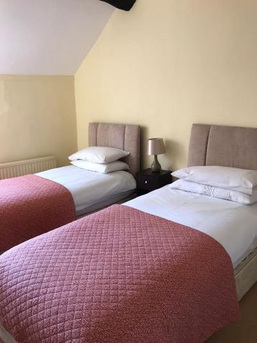 two beds sitting next to each other in a room at Bell Tower in Hereford