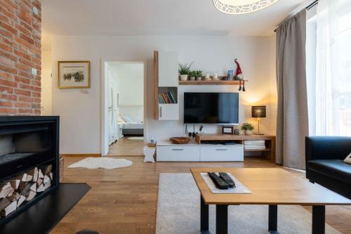 ein Wohnzimmer mit Kamin und Fernseher in der Unterkunft Apartma Peček Kranjska Gora in Kranjska Gora
