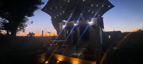 a building with an umbrella with lights on it at Chalet Studio 5kms Etretat in Villainville