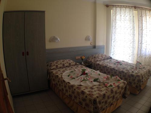 een hotelkamer met twee bedden met bloemen erop bij Semiz Apart Hotel in Alanya