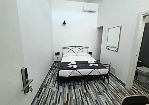 una camera da letto con un letto e uno specchio a parete di RE ARTU' a Pulsano