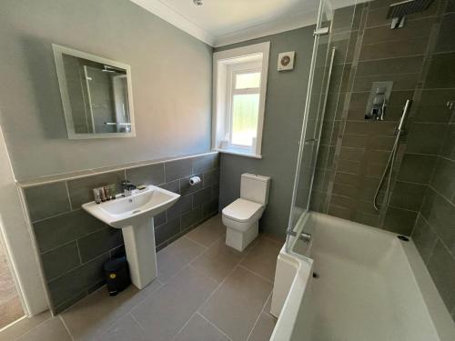 een badkamer met een wastafel, een toilet en een douche bij Bayside GuestHouse in Bournemouth