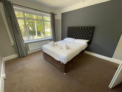 a bedroom with a bed with white sheets and a window at Bayside GuestHouse in Bournemouth
