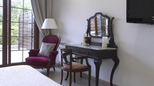 a bedroom with a desk and a mirror and a chair at Hotel Rural Playa de Aguilar in Muros de Nalón