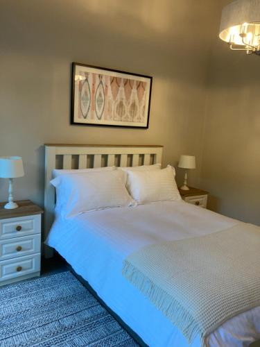 a bedroom with a bed and two night stands and two lamps at Highgrange Apartments in Dundalk