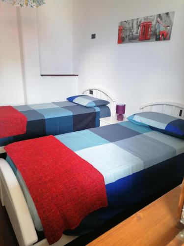 two beds sitting next to each other in a room at Acero Rosso in Malonno