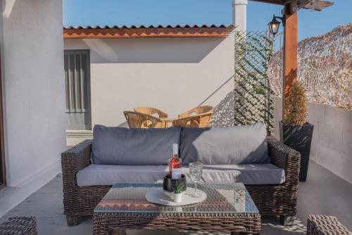 a wicker couch and a table on a patio at Cozy Loft with Private Terrace in Kremasti