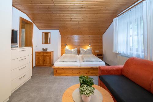 een grote slaapkamer met een bed en een bank bij Gästehaus Fitsch - Ferienwohnung in Silbertal in Silbertal