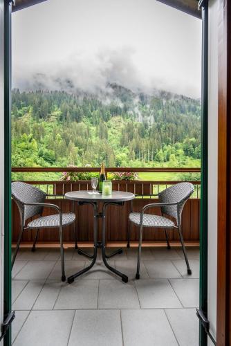 a table and chairs on a balcony with a view at Gästehaus Fitsch - Ferienwohnung in Silbertal in Silbertal