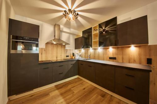 cocina con armarios negros y techo en Appartement Iglsberg Top 6, en Saalbach Hinterglemm