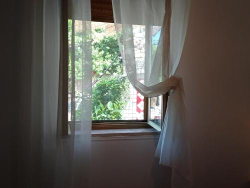 a window with a white curtain in a room at casa dei limoni in Peschici