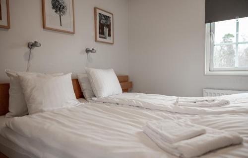Duas camas brancas sentadas uma ao lado da outra num quarto em Ekerum Village em Borgholm