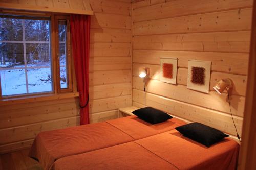 een slaapkamer met een bed in een blokhut bij Vuosselin Kruunu in Ruka