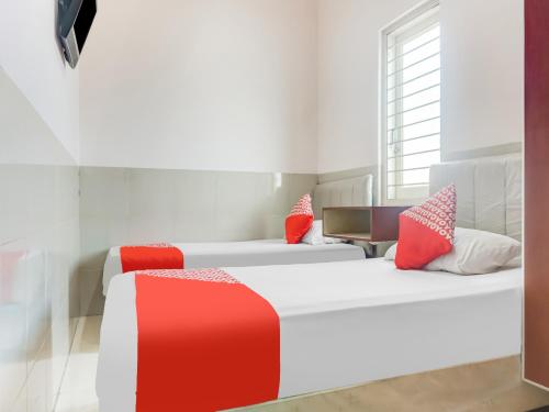Un pat sau paturi într-o cameră la OYO 91316 Hh Guest House Makassar