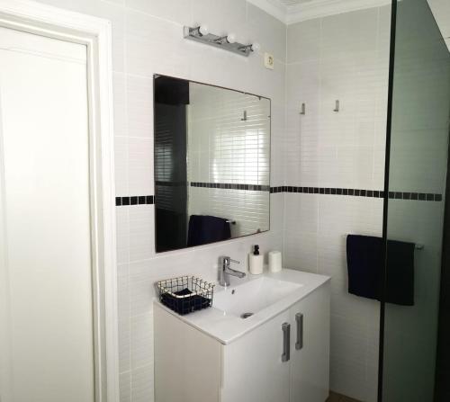 ein weißes Badezimmer mit Waschbecken und Spiegel in der Unterkunft Luisan Guanarteme in Las Palmas de Gran Canaria