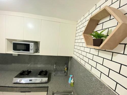 a kitchen with a stove and a microwave at RUSTIC THEMED - 2BR TownHouse - near Clark Airport - TRP4 in Mining