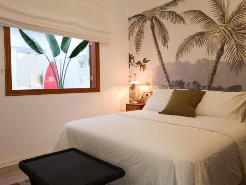 ein Schlafzimmer mit einem Bett mit einem Palmenmilch in der Unterkunft Luisan Guanarteme in Las Palmas de Gran Canaria