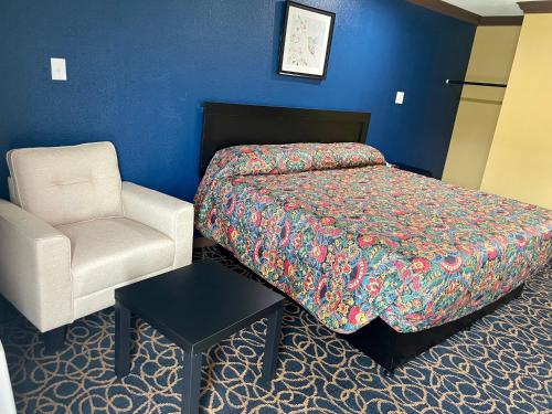 a hotel room with a bed and a chair at Super 6 Inn in Carencro