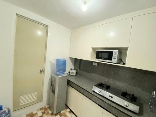 a kitchen with white cabinets and a microwave at RUSTIC THEMED - 2BR TownHouse - near Clark Airport - TRP4 in Mining