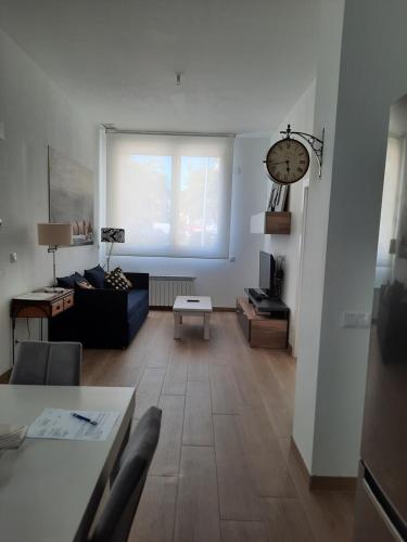 a living room with a couch and a clock on the wall at josemaenea in Pamplona
