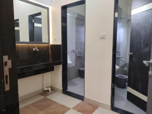 a bathroom with a toilet and a mirror at Cocorico Beach Resort in Dapoli
