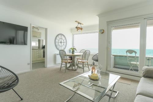 a living room with a view of the ocean at Tides - Beach front apartment in Bracklesham Bay in Chichester