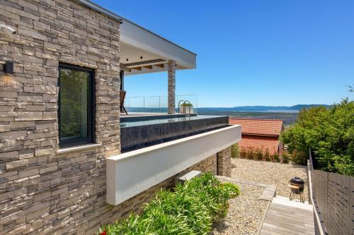 a brick house with a large window on the side of it at House7E in Šmrika