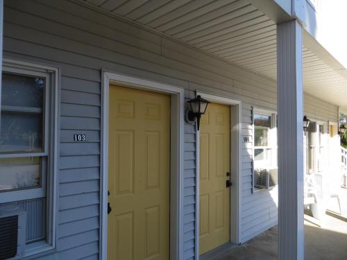 a house with two yellow doors on it at Empire Lakeshore Inn in Empire