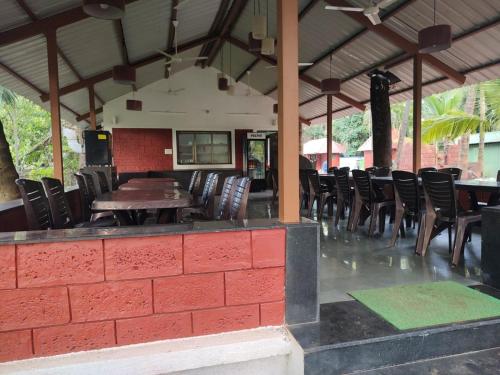 a restaurant with chairs and a table and a brick wall at Cocorico Beach Resort in Dapoli